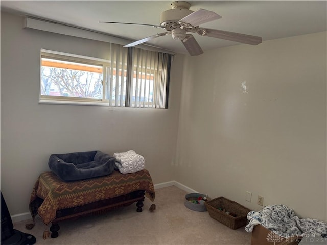 living area with carpet flooring, baseboards, and ceiling fan