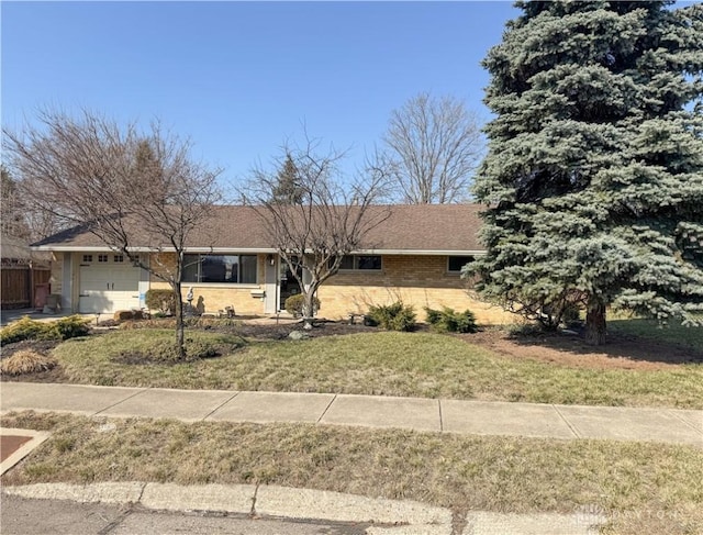 ranch-style house featuring a garage and a front lawn