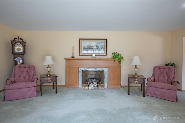 sitting room with carpet, baseboards, and a high end fireplace