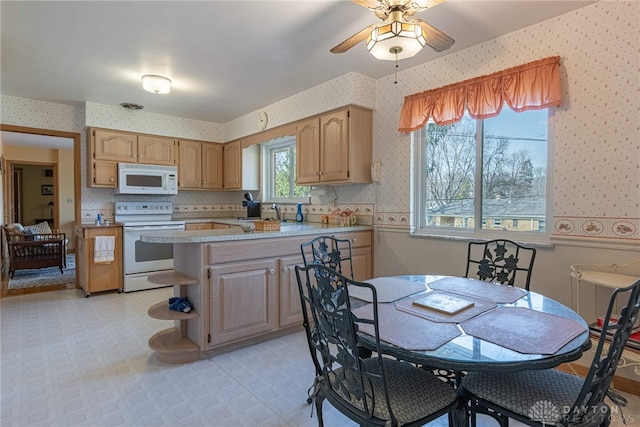 kitchen with white appliances, light floors, wallpapered walls, a peninsula, and light countertops