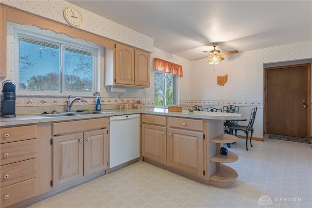 kitchen featuring wallpapered walls, dishwasher, light floors, and a sink