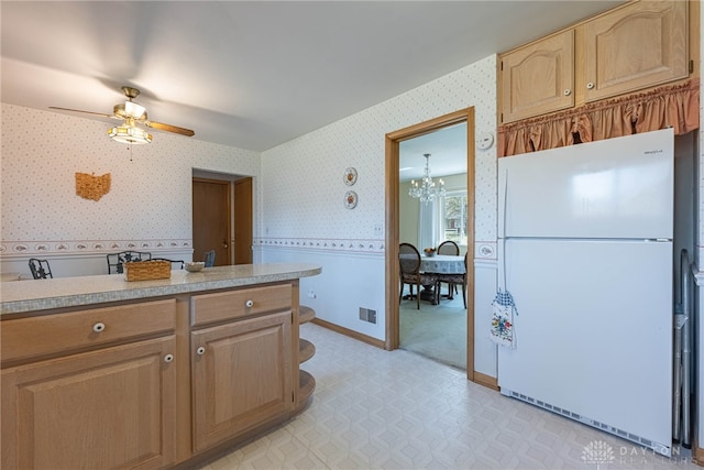 kitchen with visible vents, light countertops, freestanding refrigerator, and wallpapered walls