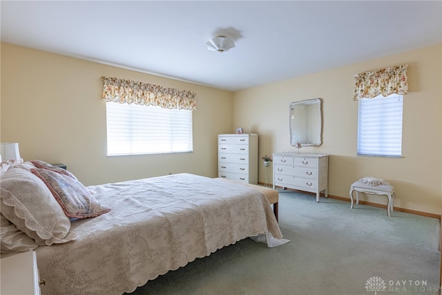 carpeted bedroom with multiple windows and baseboards