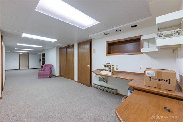 interior space with baseboards, a drop ceiling, and a baseboard radiator