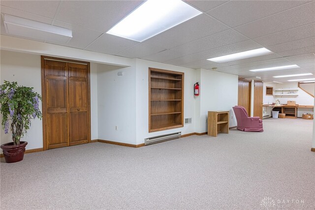 finished basement with carpet flooring, baseboards, and a baseboard radiator