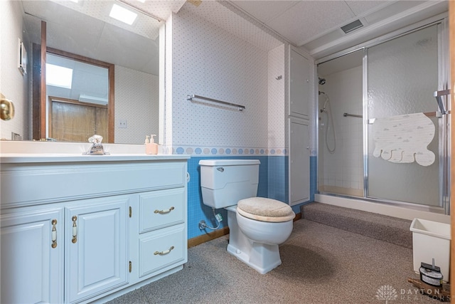 bathroom with visible vents, a stall shower, wallpapered walls, and vanity