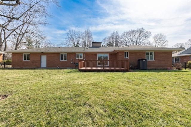 back of property featuring a yard, central air condition unit, a deck, and a chimney