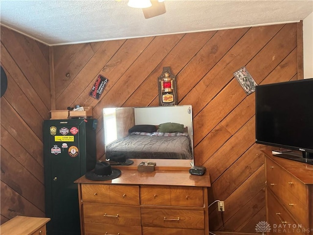 bedroom with wooden walls and a textured ceiling