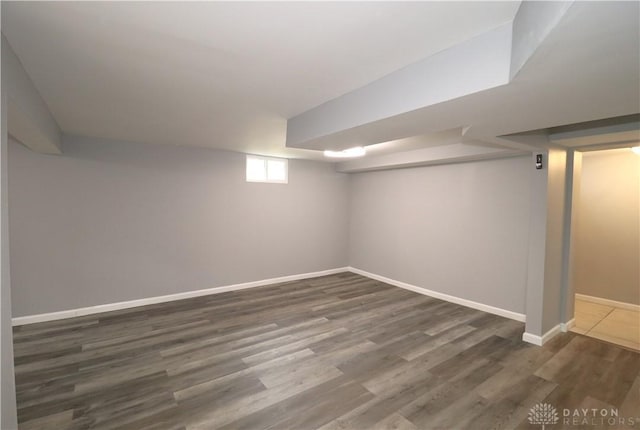 basement with dark wood-type flooring and baseboards