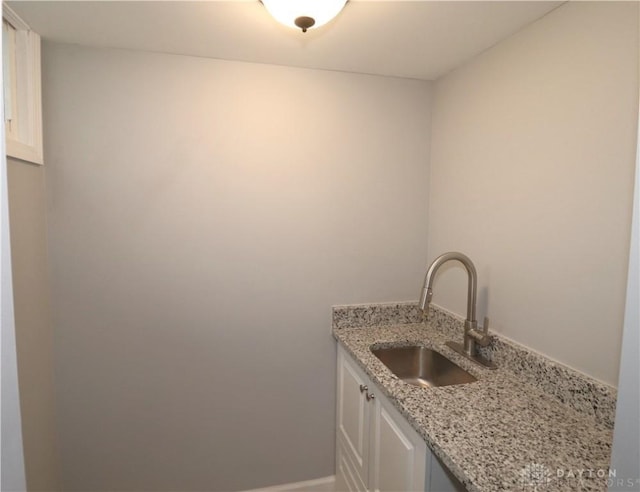 laundry room with a sink and baseboards