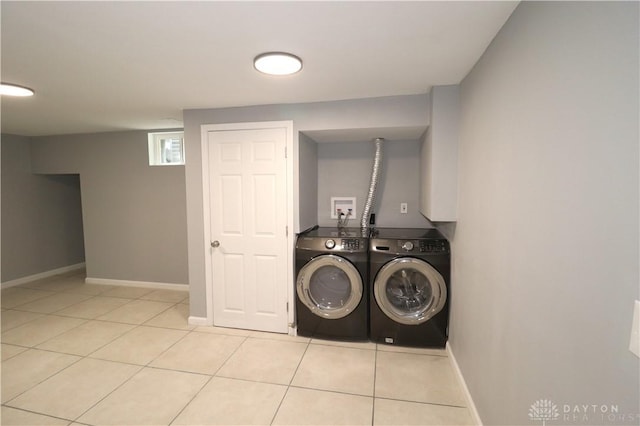 laundry room featuring washing machine and clothes dryer, laundry area, baseboards, and light tile patterned flooring