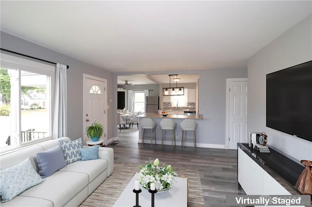 living area featuring baseboards and dark wood-style flooring