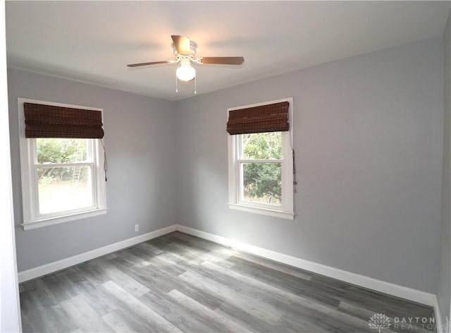 unfurnished room featuring ceiling fan, baseboards, and wood finished floors