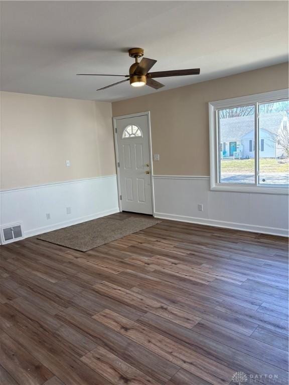 foyer featuring a ceiling fan, visible vents, dark wood-style flooring, and wainscoting