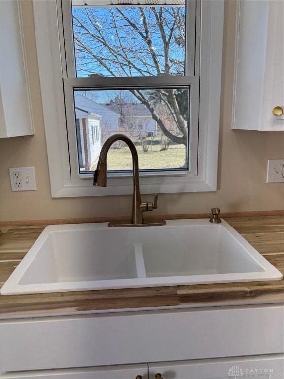 interior details featuring white cabinetry and a sink