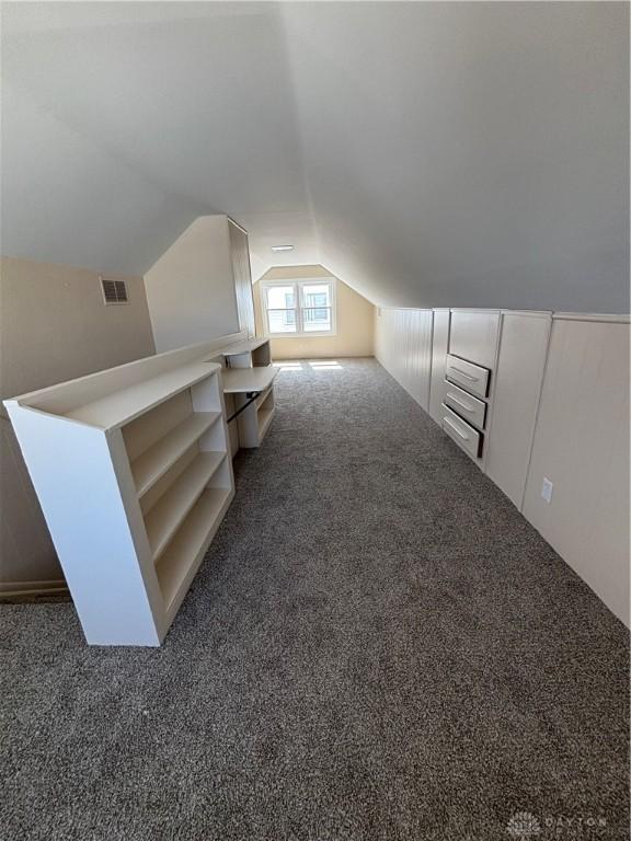 additional living space featuring vaulted ceiling, visible vents, and carpet floors