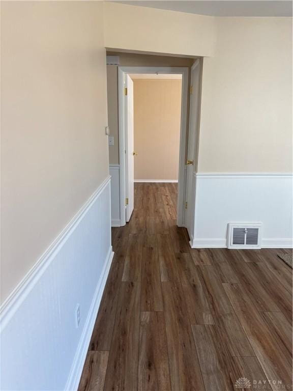 corridor featuring visible vents, wood finished floors, and wainscoting