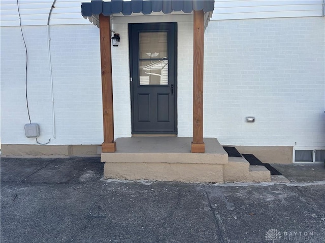 view of exterior entry with brick siding