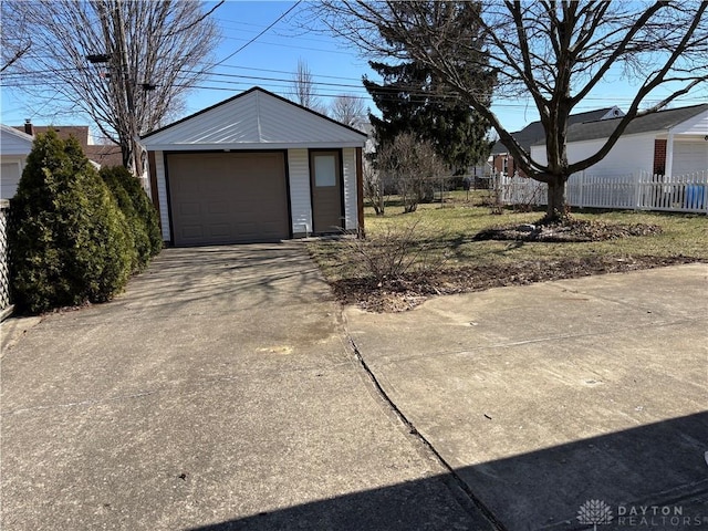 detached garage with driveway and fence