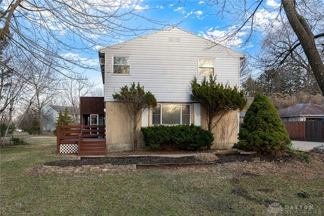 exterior space featuring a yard, brick siding, and a deck