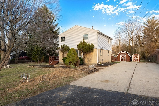 view of side of property with a storage shed and an outbuilding