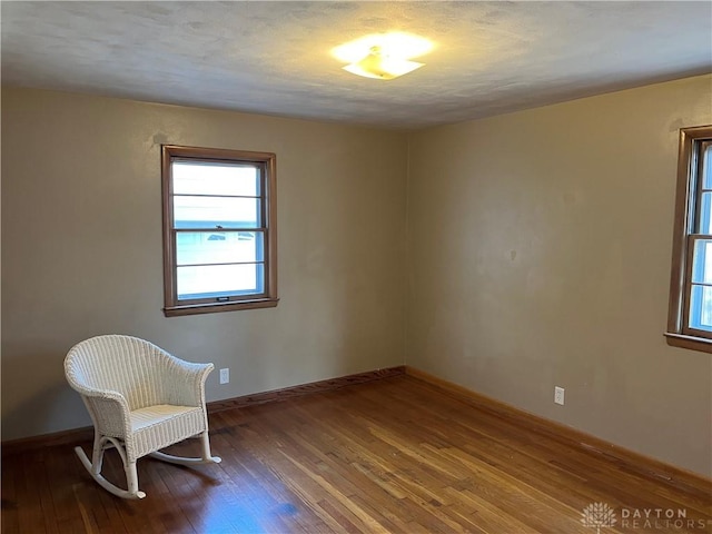 sitting room featuring baseboards and wood-type flooring