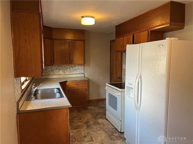 kitchen featuring tasteful backsplash, white appliances, brown cabinetry, and a sink