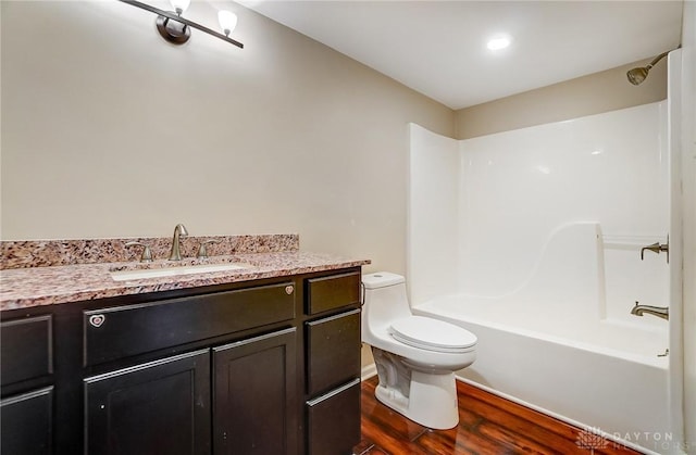 full bath featuring vanity, toilet, wood finished floors, and tub / shower combination