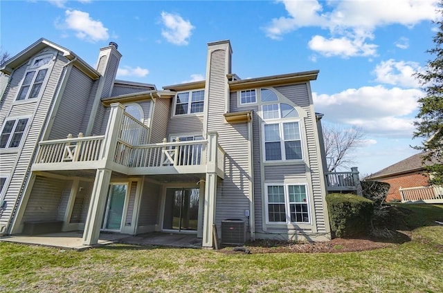 rear view of house featuring cooling unit, a lawn, and a patio area