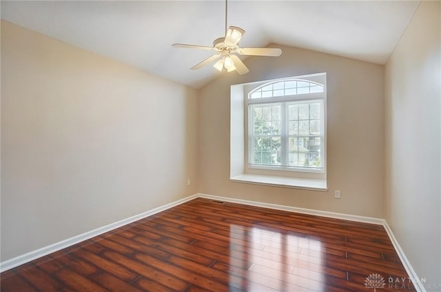 spare room with a ceiling fan, lofted ceiling, wood finished floors, and baseboards