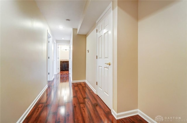 corridor featuring dark wood-style floors and baseboards