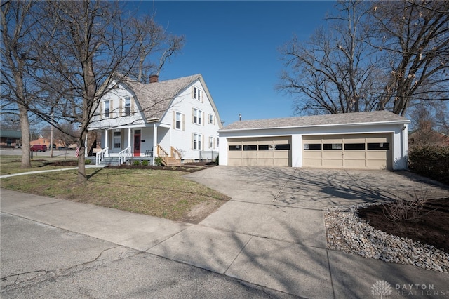 view of property exterior featuring a gambrel roof, a chimney, covered porch, a lawn, and a garage