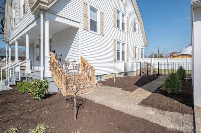 view of property exterior featuring a porch and fence