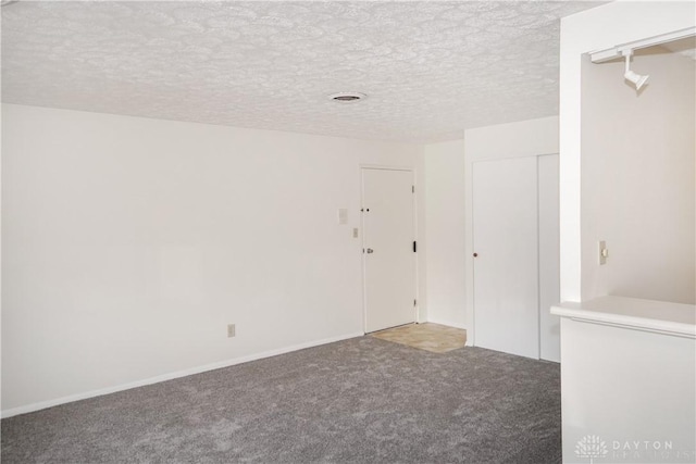 spare room featuring carpet flooring and a textured ceiling