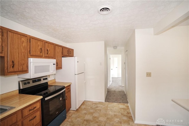 kitchen with white appliances, brown cabinetry, visible vents, light countertops, and a textured ceiling