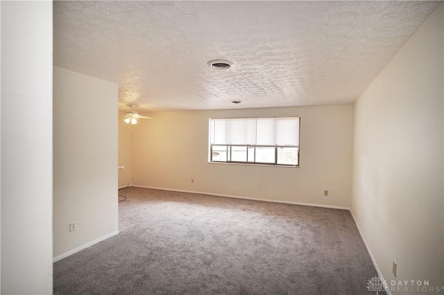 carpeted spare room with visible vents, baseboards, a textured ceiling, and a ceiling fan