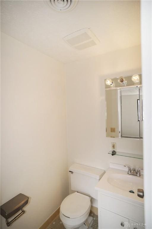 bathroom featuring visible vents, baseboards, toilet, and vanity