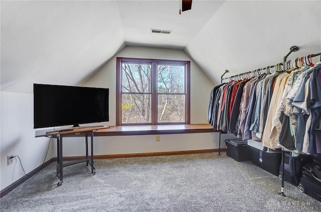 spacious closet featuring visible vents, lofted ceiling, and carpet floors