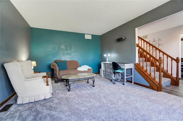 interior space featuring visible vents, carpet flooring, and an accent wall