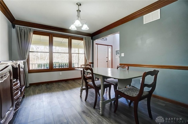 dining area featuring visible vents, baseboards, crown molding, and dark wood-type flooring