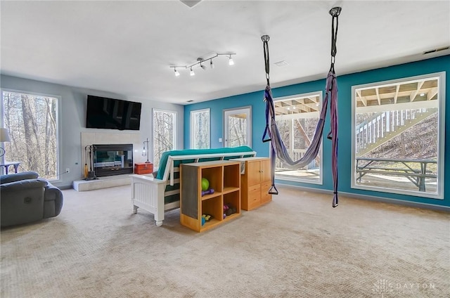 playroom with carpet flooring, visible vents, and a tile fireplace