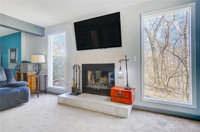 living room featuring plenty of natural light, carpet flooring, and a tiled fireplace