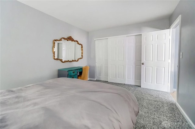 carpeted bedroom with a closet and baseboards