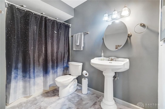 full bath featuring curtained shower, toilet, and baseboards