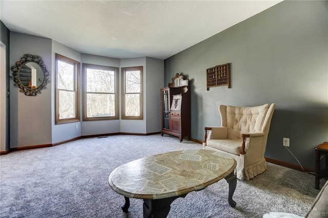 living area with light colored carpet and baseboards