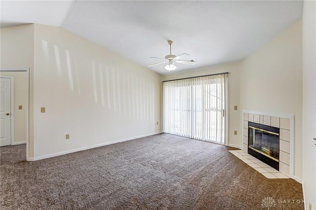 unfurnished living room with a ceiling fan, baseboards, carpet floors, vaulted ceiling, and a tiled fireplace