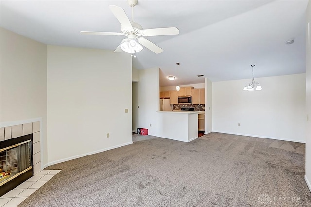 unfurnished living room with light carpet, ceiling fan with notable chandelier, a fireplace, and baseboards