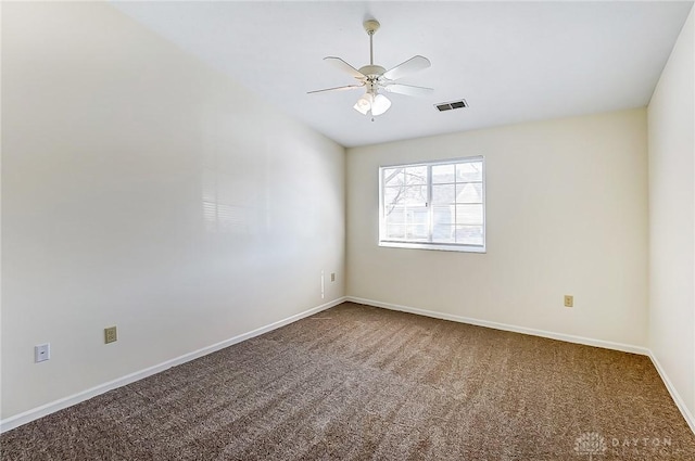 carpeted empty room featuring visible vents, baseboards, and ceiling fan