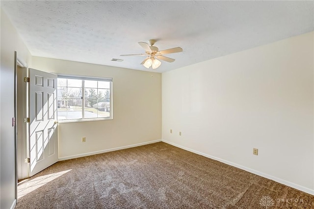 empty room featuring a ceiling fan, visible vents, carpet, baseboards, and a textured ceiling