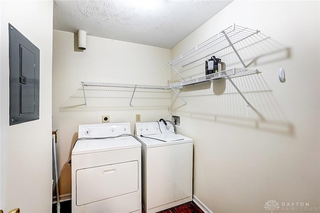 laundry area featuring baseboards, washing machine and clothes dryer, laundry area, electric panel, and a textured ceiling